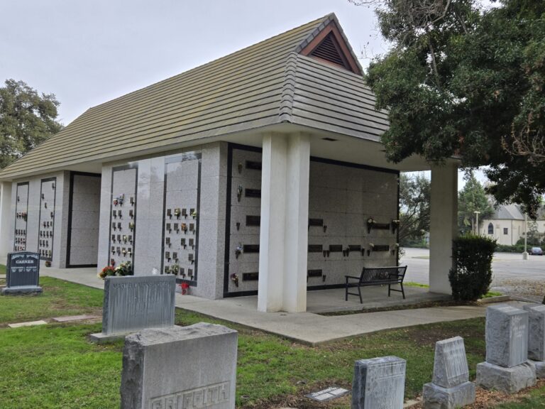 Heritage Mausoleum - Companion Niche with a stone structure, two niche walls, a bench, and surrounding greenery.