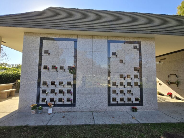 Heritage Mausoleum - Companion Niche with two vertical stone walls containing niches and decorative flowers.